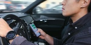 A distracted driver in a car, texting while driving.