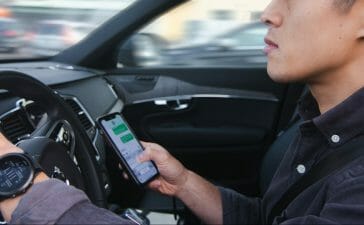 A distracted driver in a car, texting while driving.