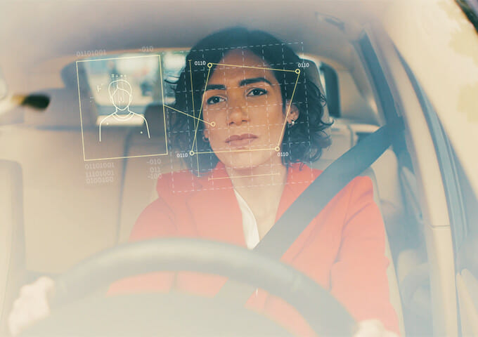 Woman in car with Driver Monitoring System metrics