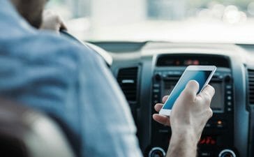 A driver not using a driver monitoring system (DMS) is distracted by their phone