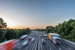 Sunset view heavy traffic moving at speed on UK motorway in England.