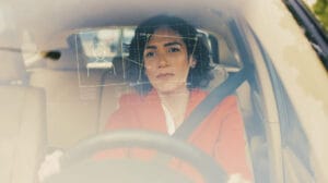 Woman in a car with driver monitoring system metrics overlay