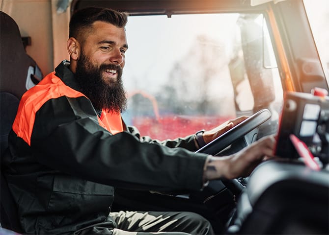 A happy truck driver interacting with his truck.