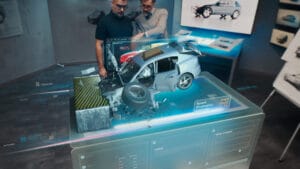 Two engineers Developers standing in design studio near futuristic holographic table and make a test in a 3d car crash test simulator, which simulates a road accident check the safety