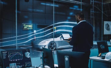 Engineering Research Agency Perform Aerodynamic Testing with a Modern Eco-Friendly Electric Sports Car in a Wind Tunnel. Professional Scientist Works on a Laptop Computer and Changes Testing Options.