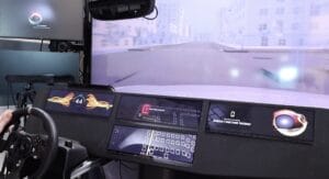 A driving simulator interface showing speed, visual alerts, and a simulated urban environment on the screen.