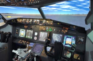 Flight simulator cockpit of a Boeing 737 with illuminated displays and control panels, representing a structured high-tech environment for eye tracking research.