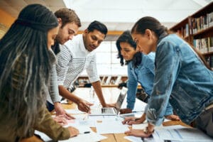 Diverse group of colleagues gathered around a table analyzing project plans and documents—highlighting teamwork in eye tracking research budgeting.