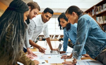 Diverse group of colleagues gathered around a table analyzing project plans and documents—highlighting teamwork in eye tracking research budgeting.