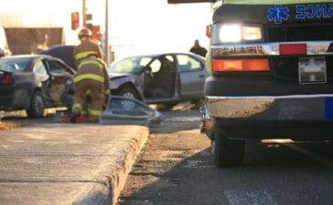 Emergency responders and ambulance at the scene of a two-car crash, illustrating the critical role of accurate crash data and timely eCall alerts in rescue operations.