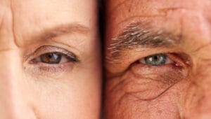 Close-up of an older woman’s and man’s eyes side by side, illustrating how age-related changes in facial features and skin texture can impact eye tracking performance.