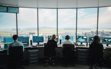 Air traffic controllers working in a modern tower with multiple screens and radar displays, a typical multi-screen setup for complex eye tracking research.