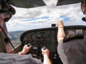 Pilots in a cockpit simulator monitoring instruments during flight training, illustrating visual attention, scanning behavior, and situational awareness.